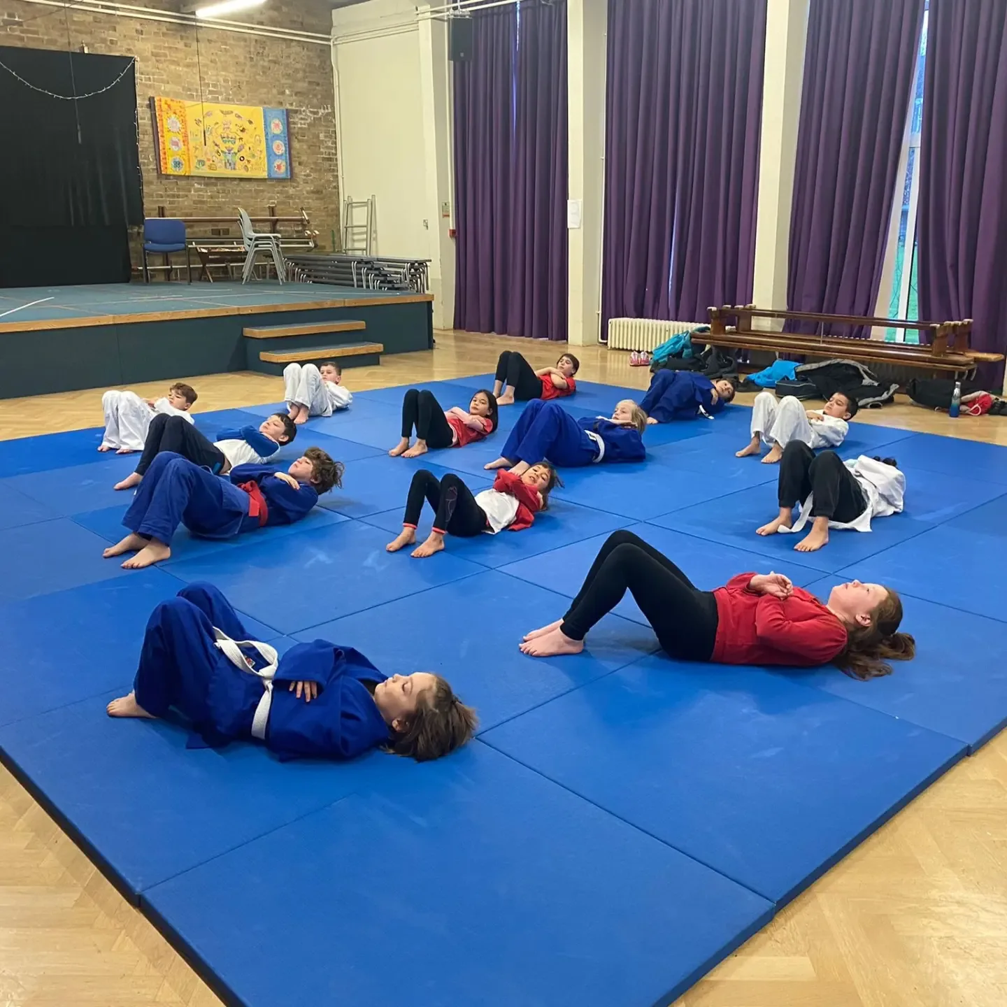 Children practise breakfalls on the mats