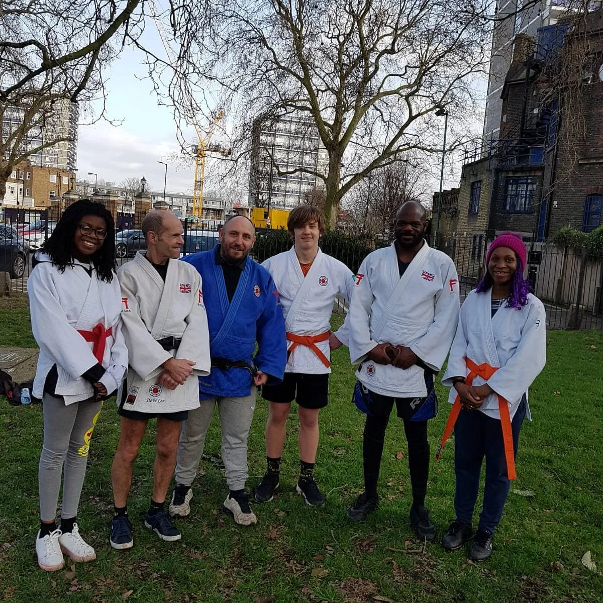 Students with coloured belts training outdoors