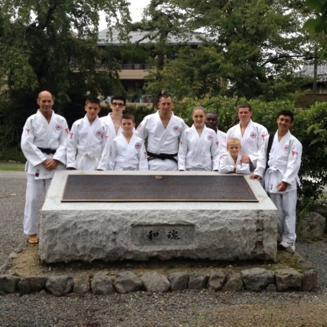 Group in judogi at a stone monument, Kyoto